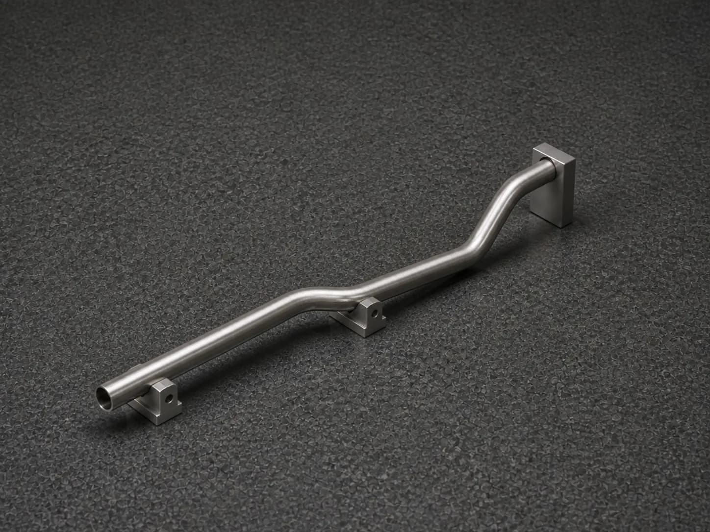Illustrative two-bend stainless tube in a modular inspection fixture showing a primary bend and straight tangent legs, one open end with visible wall, and a raised terminal leg in a rotated second bend plane