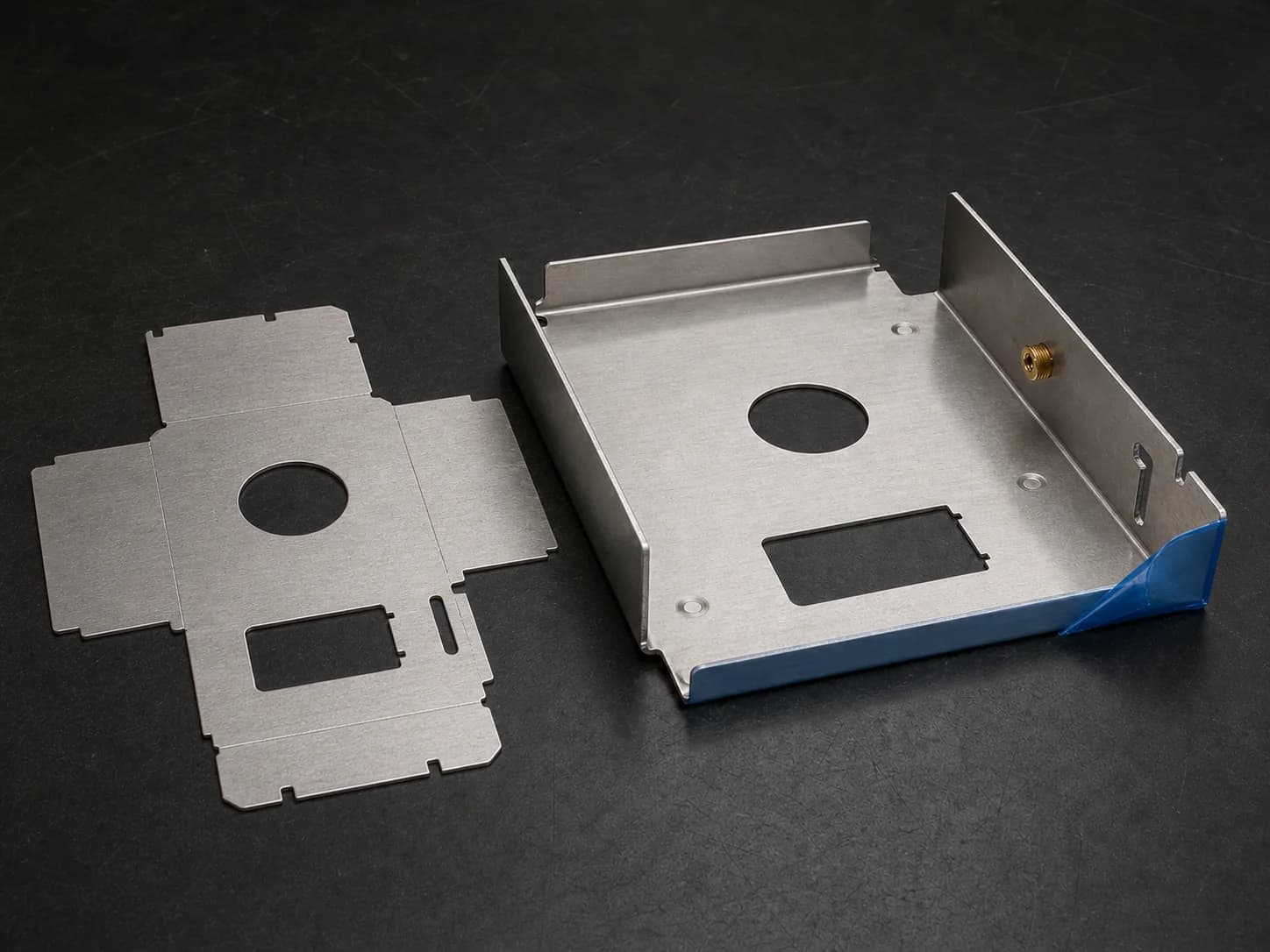 Illustrative sheet-metal planning layout with a matching stainless flat blank and formed chassis showing cutouts and reliefs, two bend-and-flange relationships, and a self-clinching insert beside a protected mating edge