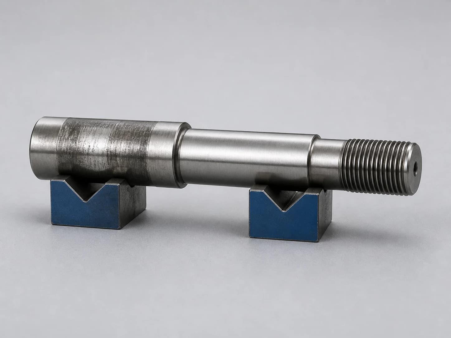 Illustrative used steel shaft showing a worn journal, stepped diameters, a finished shoulder, and an external thread with relief