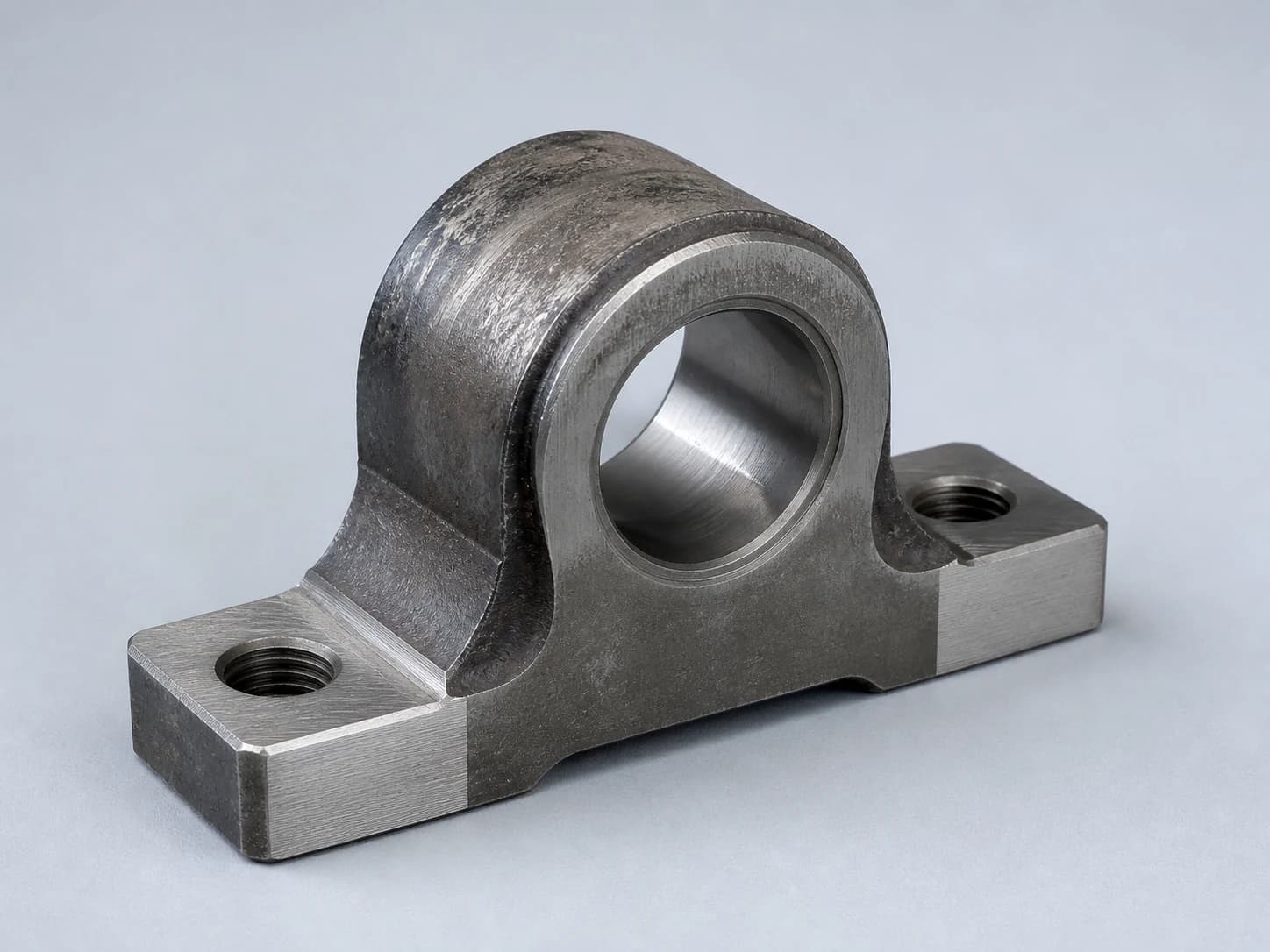 Illustrative used steel bearing block showing existing wear, machined datum faces, a finished bore, and threaded mounting holes